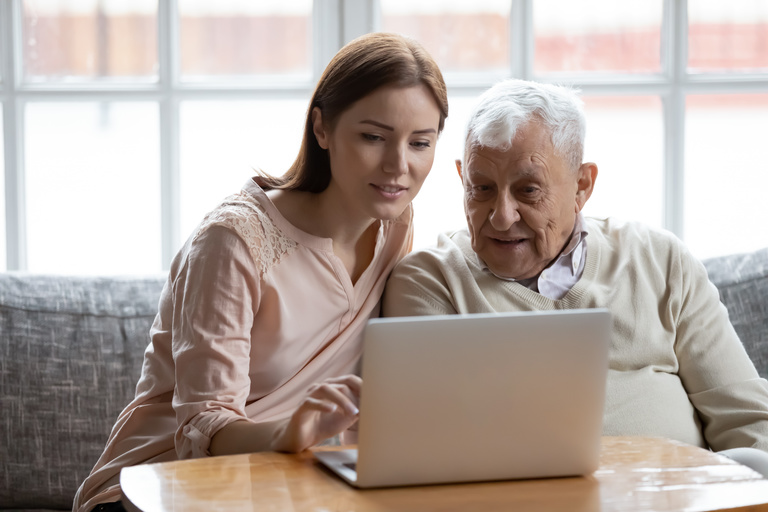 Älterer Mann bekommt Hilfe am Laptop Älterer Mann bekommt Hilfe bei der Nutzung von einem Laptop